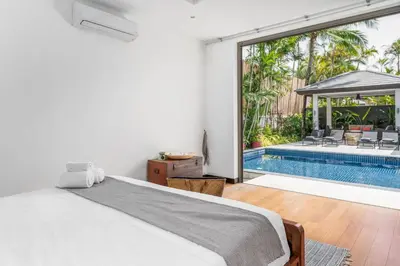 a bedroom with a bed and a swimming pool at Tropical 3BR Holiday Villa with Pool, BBQ, and Shaded Patio within Walking Distance to Bang Tao Beach in Bang Tao Beach