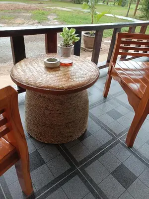 a rattan table sitting on a porch with two chairs at Baan I Ta Lay Koh Yao Noi in Ko Yao Noi