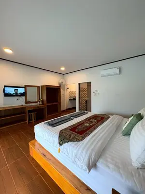 a bedroom with a large bed with a tv on the wall at Baan I Ta Lay Koh Yao Noi in Ko Yao Noi