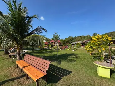 a park with a wooden bench and palm trees at Baan I Ta Lay Koh Yao Noi in Ko Yao Noi
