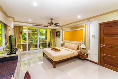 a bedroom with a bed and a flat screen tv at Karon View Apartments in Karon Beach