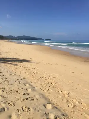 a beach with footprints in the sand and the ocean at Karon View Apartments in Karon Beach