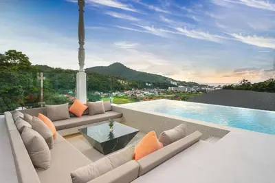a living room with a couch and a swimming pool at Capucine Villas in Kamala Beach