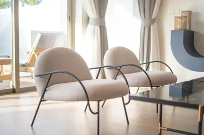 two white chairs sitting next to a glass table at Capucine Villas in Kamala Beach