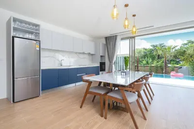 a kitchen and dining room with a table and chairs at Capucine Villas in Kamala Beach