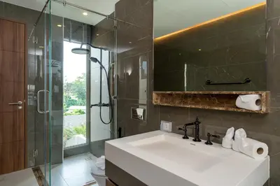 a bathroom with a sink and a glass shower at Capucine Villas in Kamala Beach