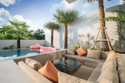 a living room with a couch and a glass table at Capucine Villas in Kamala Beach