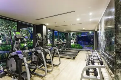 a gym with several treadmills and elliptical machines at The Deck patong Luxury Apartments The Deck patong in Patong Beach