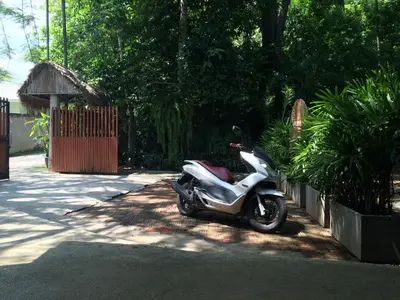 a motor scooter parked in a parking lot at Fern House Retreat in Chalong