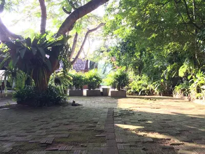 a garden with a tree and a brick path at Fern House Retreat in Chalong