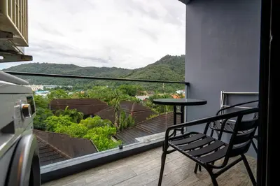 a table and a chair on a balcony with a view at Suite Celeste 1BR Sunset RooftopCitygate Kamala in Kamala Beach
