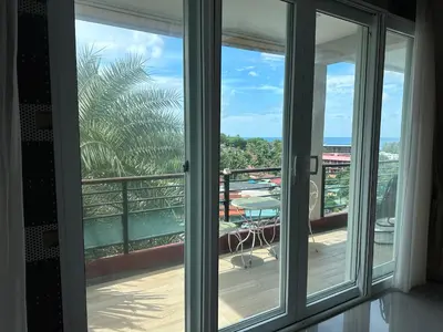 a room with a window with a view of a balcony at Phuket Condominium Karon beach in Karon Beach