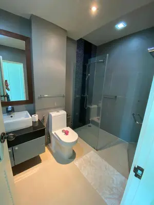 a bathroom with a toilet and a glass shower at Phuket Condominium Karon beach in Karon Beach