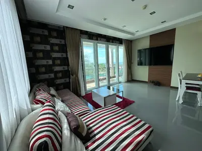 a living room with two couches and a large window at Phuket Condominium Karon beach in Karon Beach