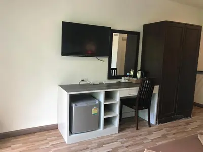 a desk with a television and a chair in a room at PP Midnight Hotel in Phi Phi Don