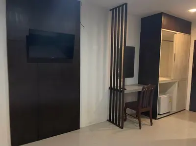 a room with a tv and a desk and a chair at PP Midnight Hotel in Phi Phi Don