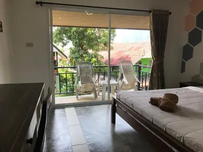 a bedroom with a bed and a view of a balcony at PP Midnight Hotel in Phi Phi Don