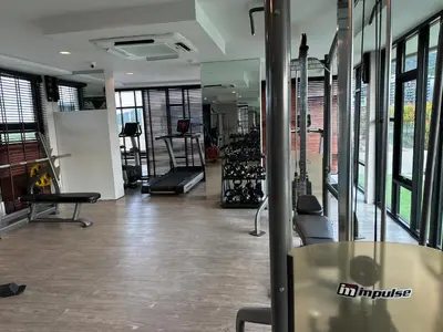 a large room with a gym with a lot of windows at Phuket apartment surin beach in Thalang