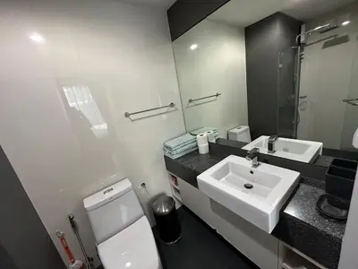 a bathroom with a sink and a toilet and a mirror at Phuket apartment surin beach in Thalang