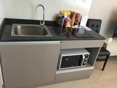 a kitchen counter with a sink and a microwave at Phuket apartment surin beach in Thalang