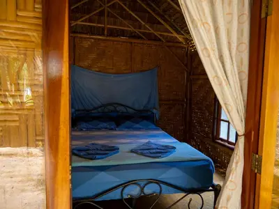 a bedroom with a bed with blue sheets at Bananas Resort & Restaurant in Tha Lane Bay