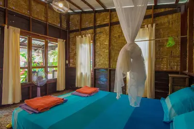 a bedroom with a blue bed and a window at Bananas Resort & Restaurant in Tha Lane Bay