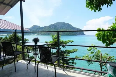 a balcony with a table and chairs and the ocean at Phi Phi Seaside Bungalow in Phi Phi Don