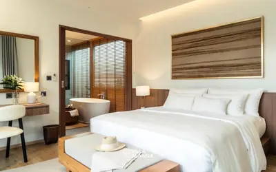 a bedroom with a large white bed and a bathroom at Villa Alanna Phuket in Bang Tao Beach