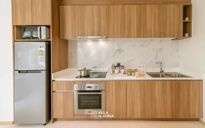 a kitchen with a refrigerator and a stove at Villa Alanna Phuket in Bang Tao Beach