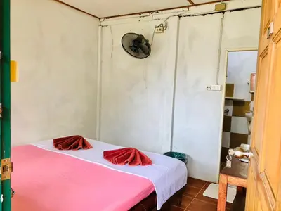 a room with a bed with red pillows on it at JR GYM & Resort in Phi Phi Don