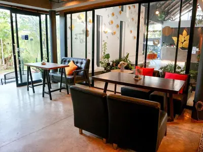 a restaurant with two tables and chairs and windows at Z&Z Resort in Rawai Beach