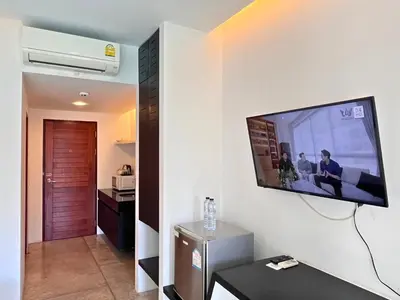 a living room with a flat screen tv on a wall at Z&Z Resort in Rawai Beach