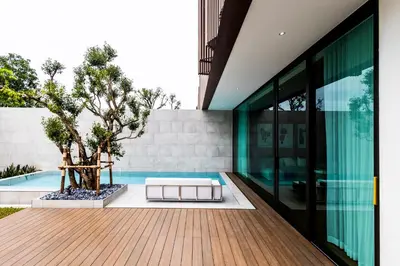 an external view of a house with a pool and a tree at Mono Oxygen Modern Pool Villas- Bangtao Beach in Phuket Town