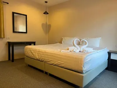 a bedroom with a bed with two swans on it at ViVi Hotel Resort in Phuket Town