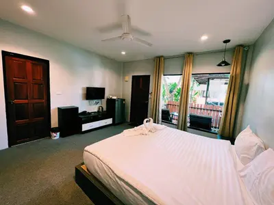 a bedroom with a bed and a ceiling fan at ViVi Hotel Resort in Phuket Town