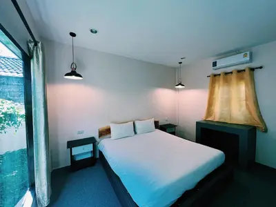 a bedroom with a white bed and a window at ViVi Hotel Resort in Phuket Town