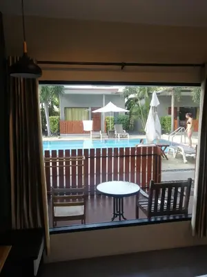 a balcony with a table and chairs and a pool at ViVi Hotel Resort in Phuket Town
