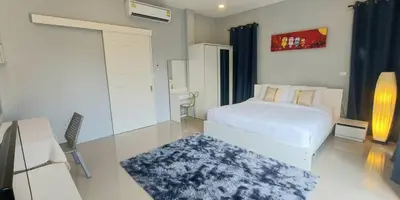 a bedroom with a bed and a desk with a rug at Udomsuk villa phuket in Bang Tao Beach