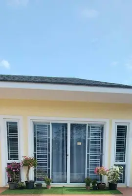 a house with windows and potted plants on it at Udomsuk villa phuket in Bang Tao Beach