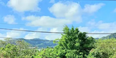 a view of trees and a blue sky with clouds at Udomsuk villa phuket in Bang Tao Beach