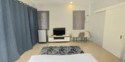 a living room with a bed and a television at Udomsuk villa phuket in Bang Tao Beach