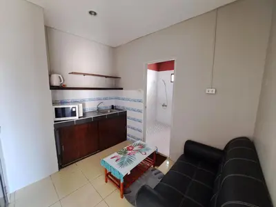 a living room with a couch and a kitchen at Lily Holiday hotel \u767e\u5408\u5047\u65e5\u9152\u5e97 in Patong Beach