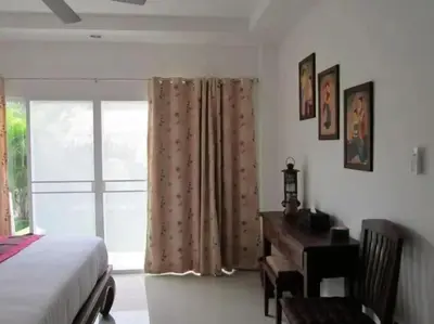 a bedroom with a bed and a desk and a window at Wonderful Villa in Rawai with Private Pool in Rawai Beach
