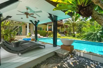 a swimming pool with a hammock and a house at Wonderful Villa in Rawai with Private Pool in Rawai Beach