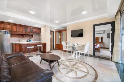 a living room and kitchen with a couch and a table at Nai Harn Beach Condominium in Nai Harn Beach