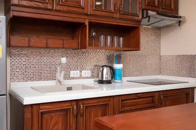 a kitchen with wooden cabinets and a sink at Nai Harn Beach Condominium in Nai Harn Beach