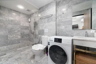 a bathroom with a washing machine and a toilet at Nai Harn Beach Condominium in Nai Harn Beach