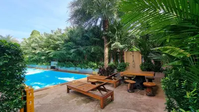 a patio with benches next to a swimming pool at Nai Harn Beach Condominium in Nai Harn Beach