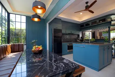 a kitchen with blue cabinets and a black counter top at Best Holidays - Oxygen pool, Billard, Gym! 2-Storey Tropical Villa Havana N in Kamala Beach