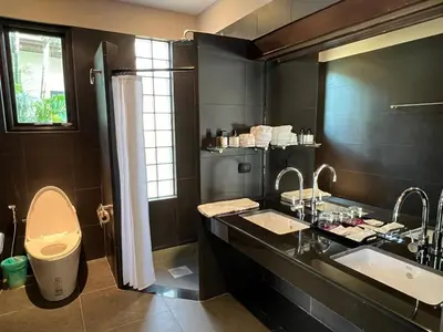 a black bathroom with two sinks and a shower at Beautiful villa walking distance from Bangtao Beach in Bang Tao Beach